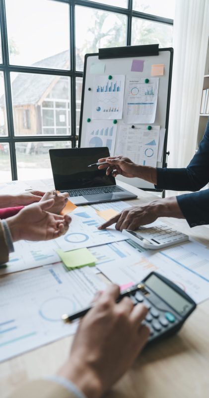 Teamwork of asian business people discussing and calculating with calculator on evaluation data in conference room. with the growth and pointing to the chart graph financial account.